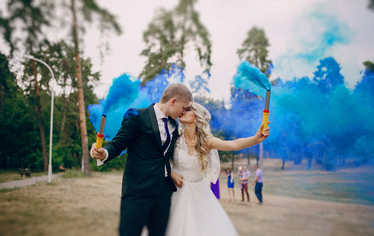 Wedding couple runs blue smoke in the park